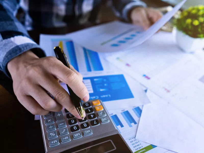 Businessman using calculator and reading document