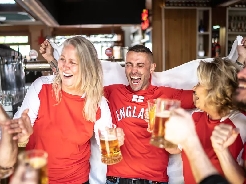 Friends celebrating English team winning in a bar