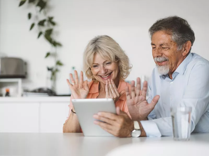 Grandparents waving goodbye to family over video call