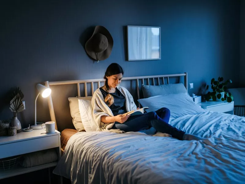 Woman reading a book at night