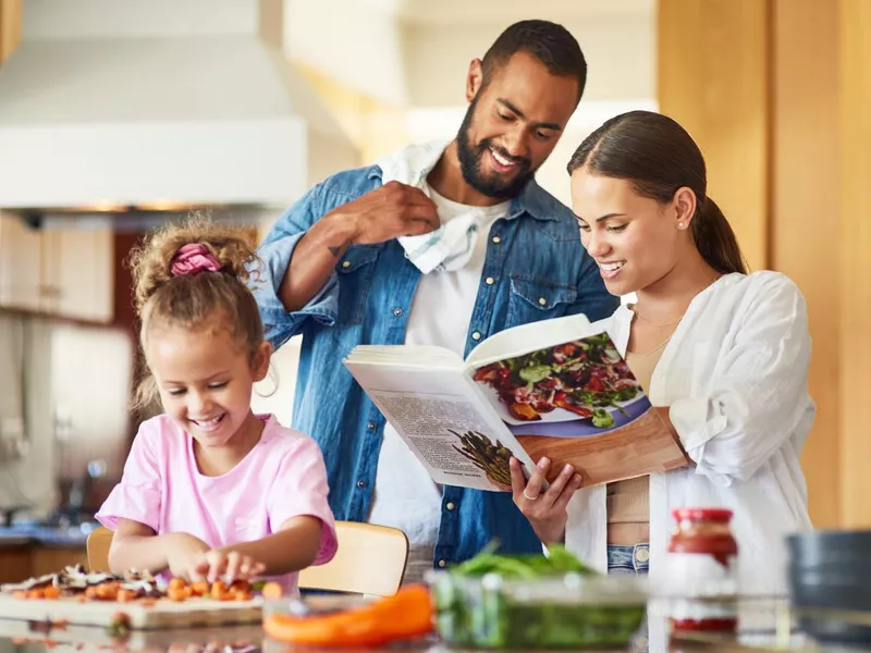 Couple and their daughter cooking together in the kitchen