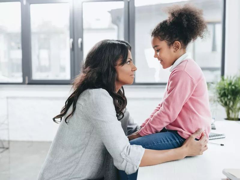 Mother talking with her daughter indoors