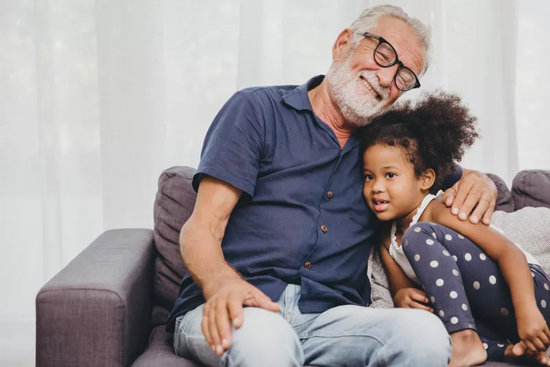 Grandfather embraces little girl