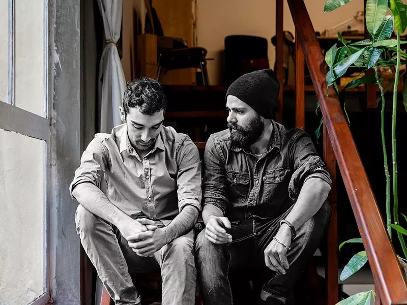 Couple of young men talking on the stairs