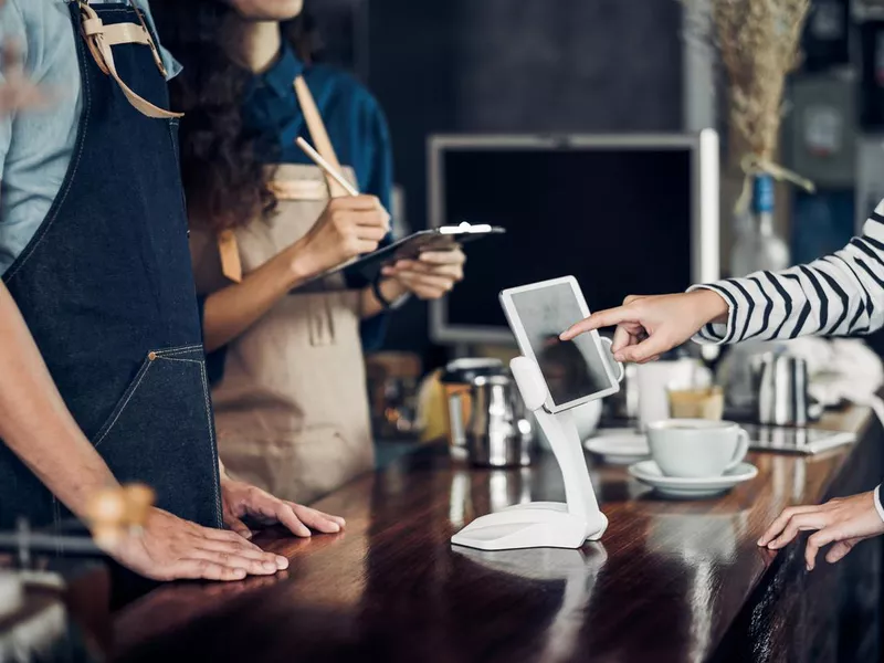 customer self service order drink menu with tablet screen at cafe counter bar,seller coffee shop accept payment by mobile.digital lifestyle concept.Blank space for display of design.