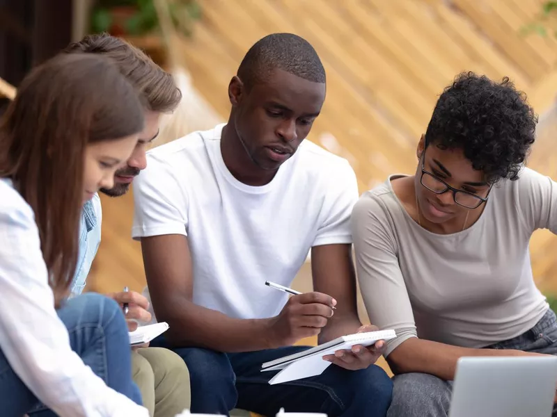 Smart students learning together sitting in cozy place