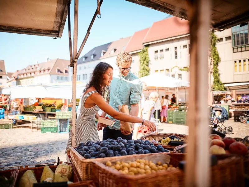 Couple shop at outdoor summer fruit market