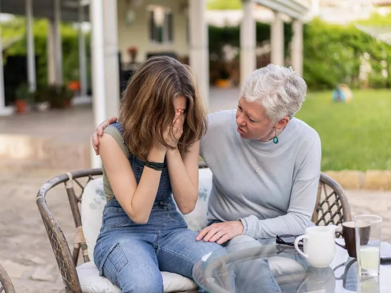 A grandmother comforts her upset grandchild