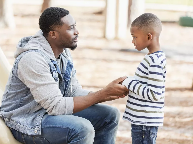 Father talking to little boy on playground