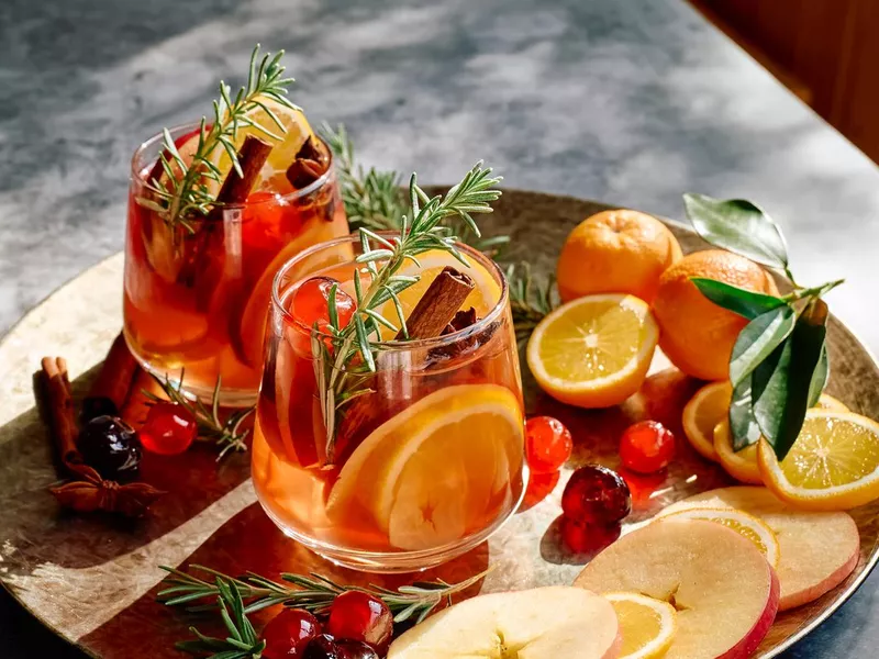 Mulled wine or christmas sangria with aromatic spices, apple, cherry and citrus fruits. Traditional Christmas festive warming spiced drink with orange, berry, cinnamon, cardamom and anise.