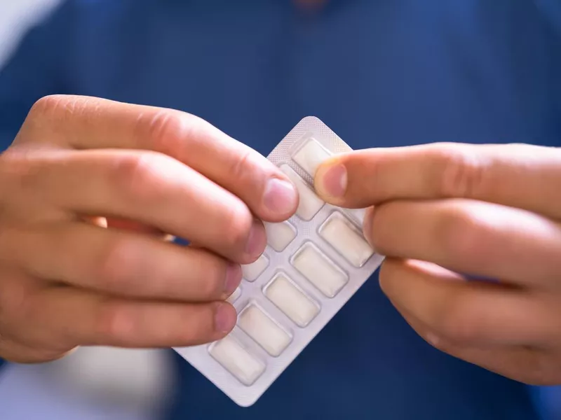 Man using nicotine gum to quit smoking