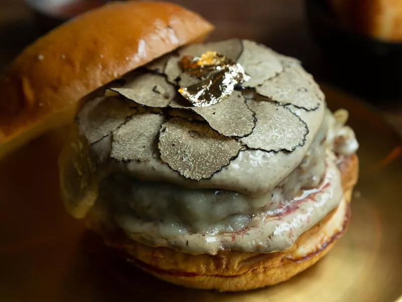 Hamburger topped with slice black truffles