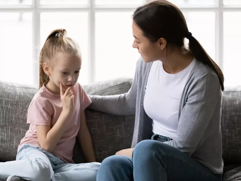 Serious mother talking to sad upset preschooler daughter