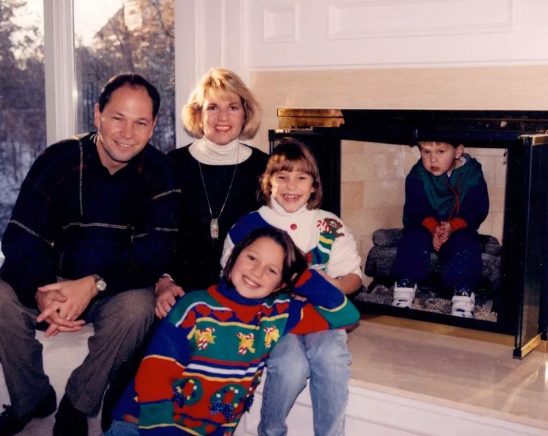 Family with kid sitting in the fireplace