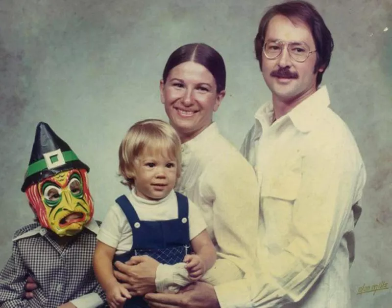 Funny family photo with one child wearing a silly mask