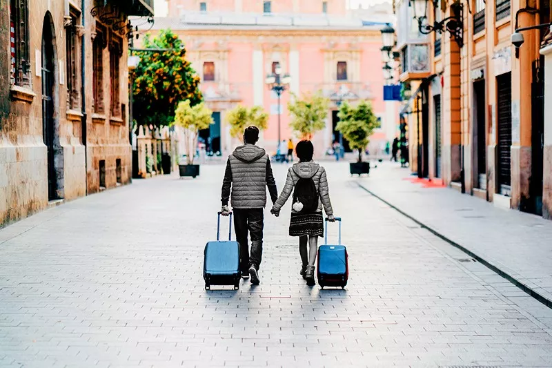 Young couple with suitcases just arriving in Valencia