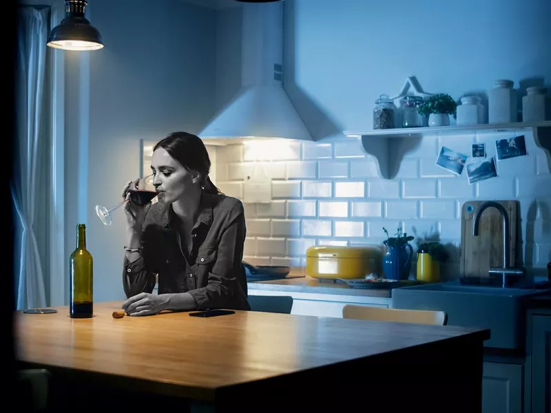 Woman drinking wine late at night