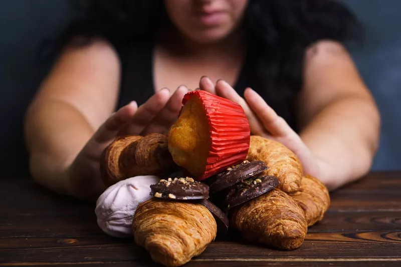 Young woman refusing to eat junk food