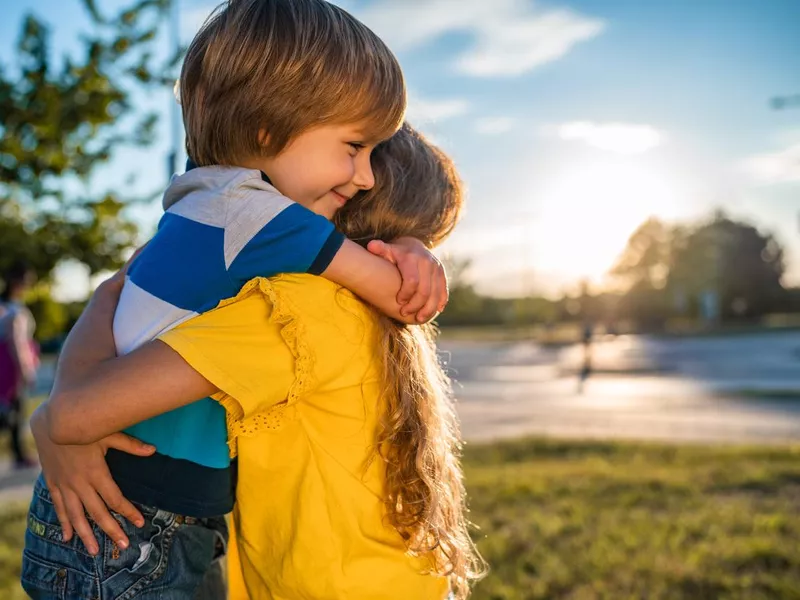 Kids hugging in public park