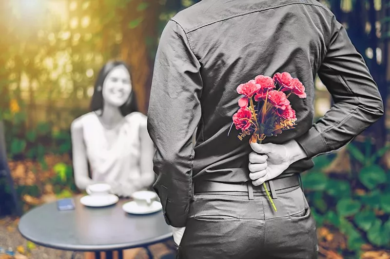 Man surprising woman with flowers