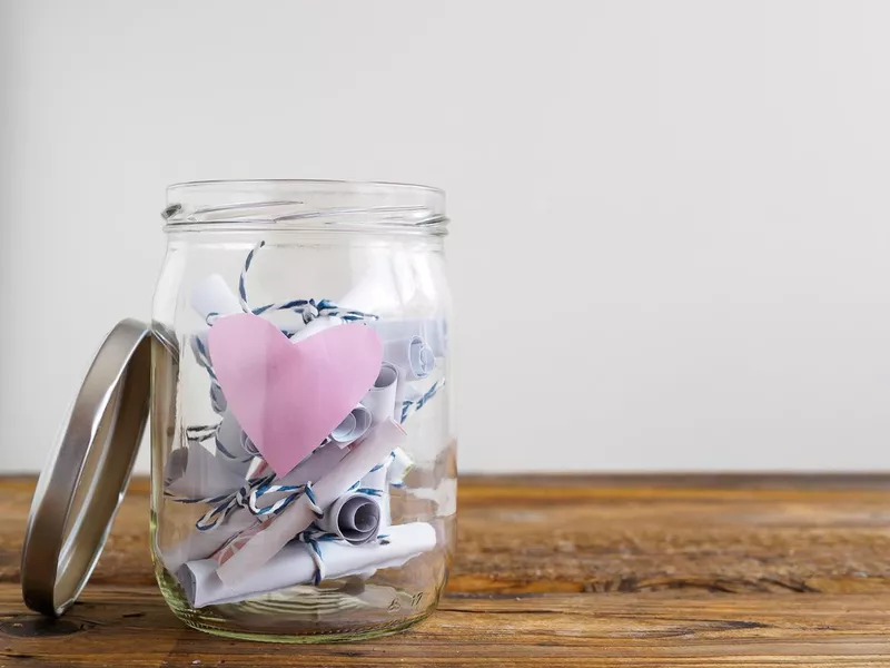 Jar with pink heart and rolled-up notepads