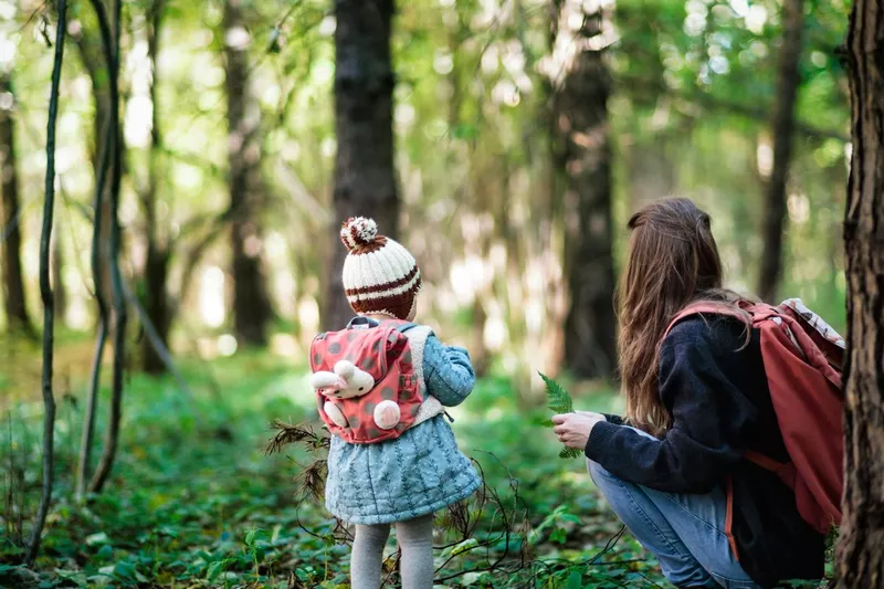 Mother and daughter looking into the forest