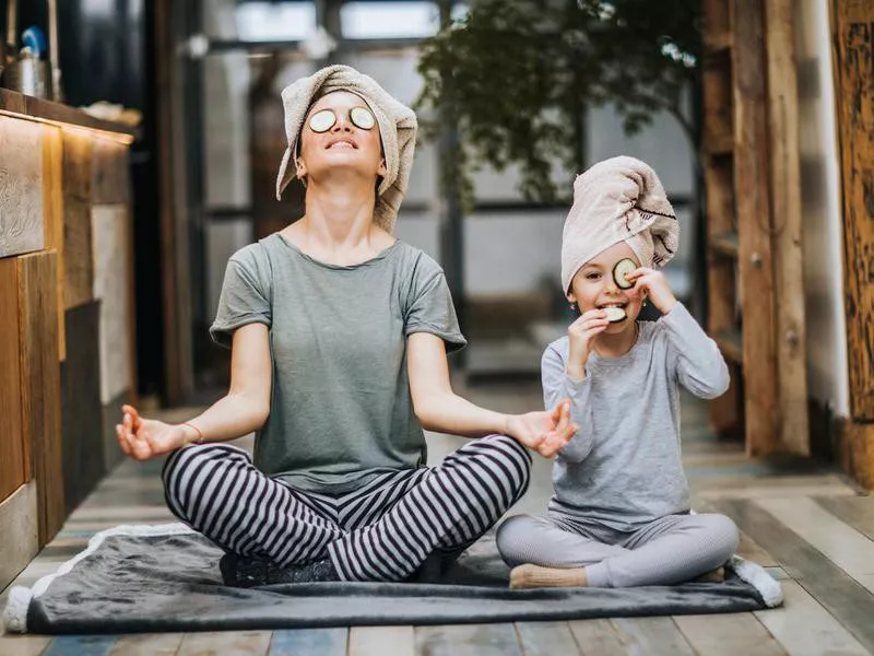 Relaxed mother and daughter exercising Yoga in the morning at home.