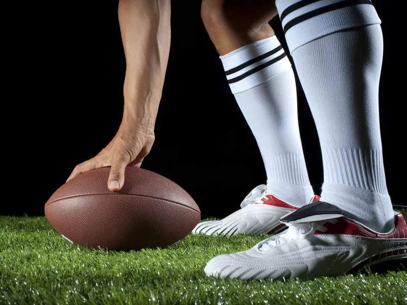 Man hiking a gridiron ball