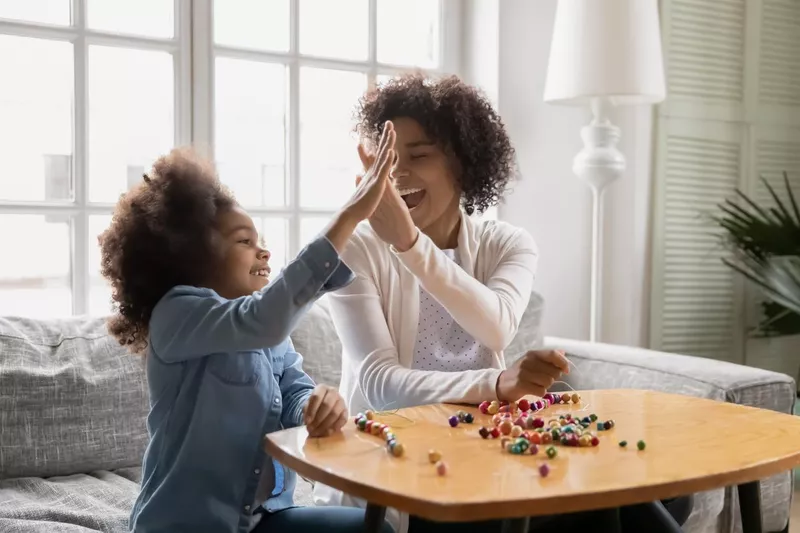 Little girl gives high five to mother