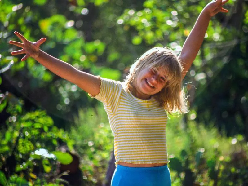 Young girl smiling with her arms outstretched