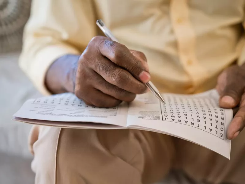 Elderly man solving puzzle