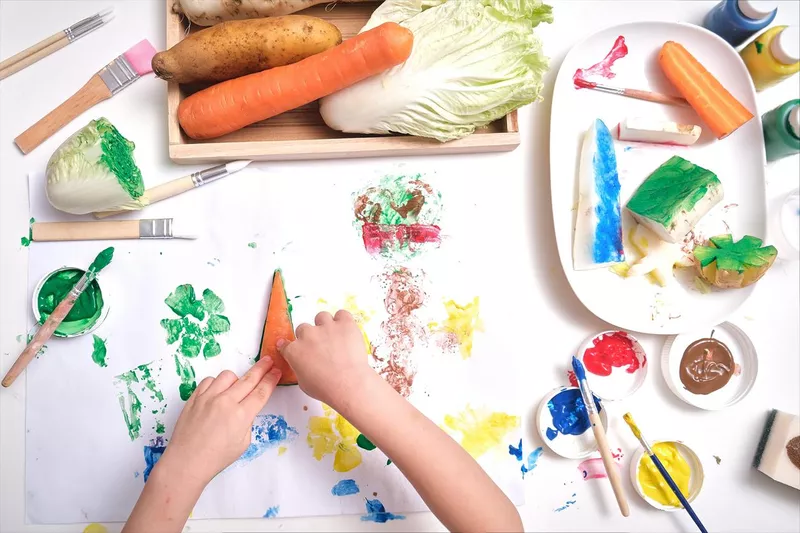 Kid making artwork from vegetable stamping