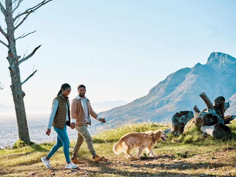 Shot of a young couple hiking with their dog out in nature