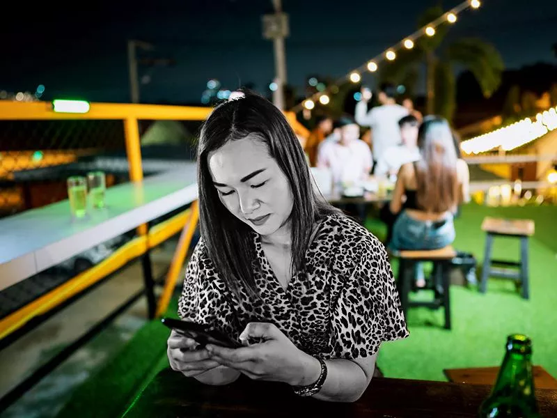 Woman on her phone at outdoor restaurant