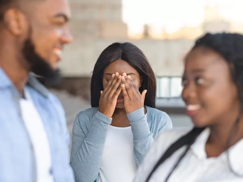 Friend with hands over face