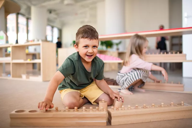 Group of small nursery school children playing indoors in classroom