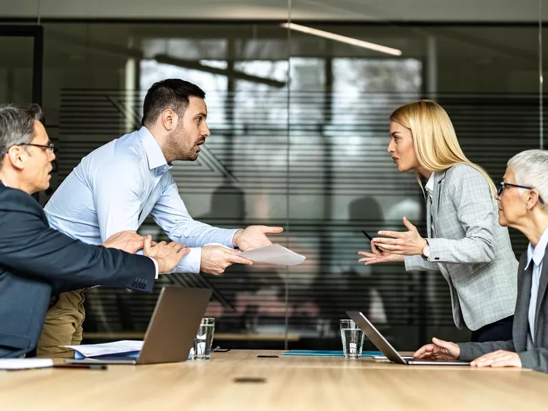 Young couple arguing about paperwork on a meeting with their lawyers.