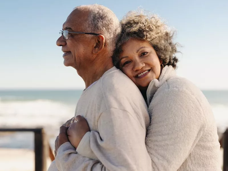 woman embracing her husband by the ocean