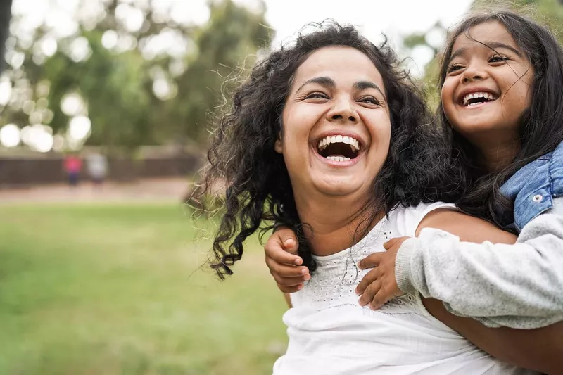 Happy mother having fun with her daughter outdoors