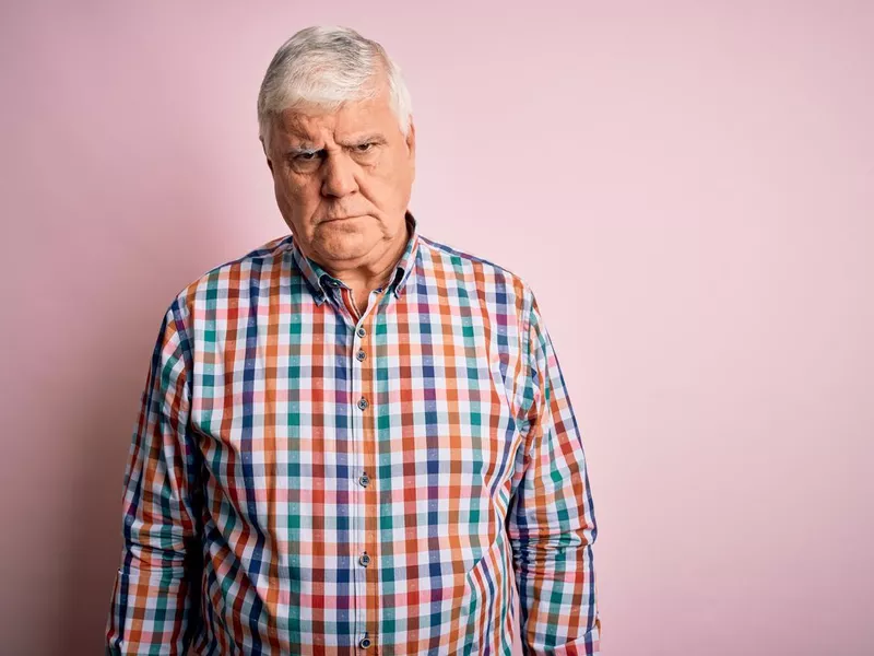 Senior handsome hoary man wearing casual colorful shirt over isolated pink background skeptic and nervous, frowning upset because of problem. Negative person.