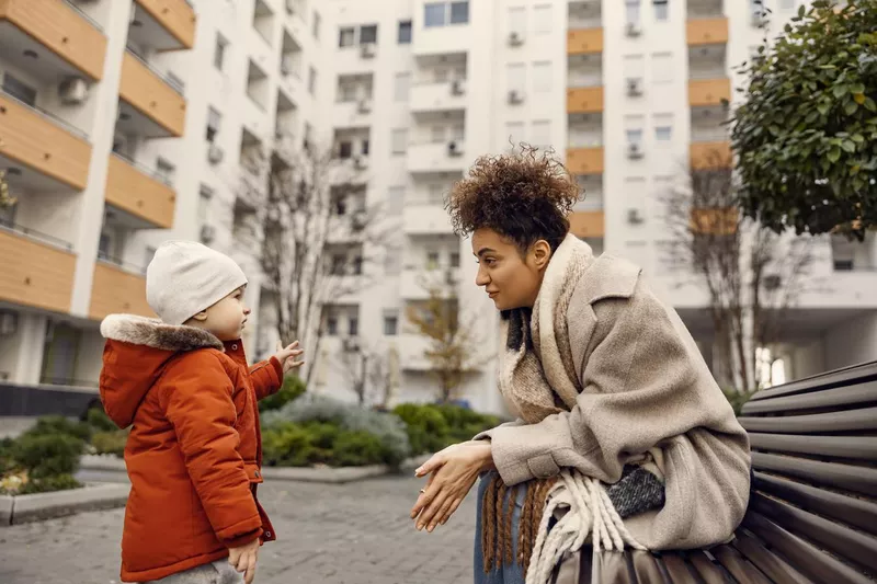 Kindergarten child talking to caregiver in the park