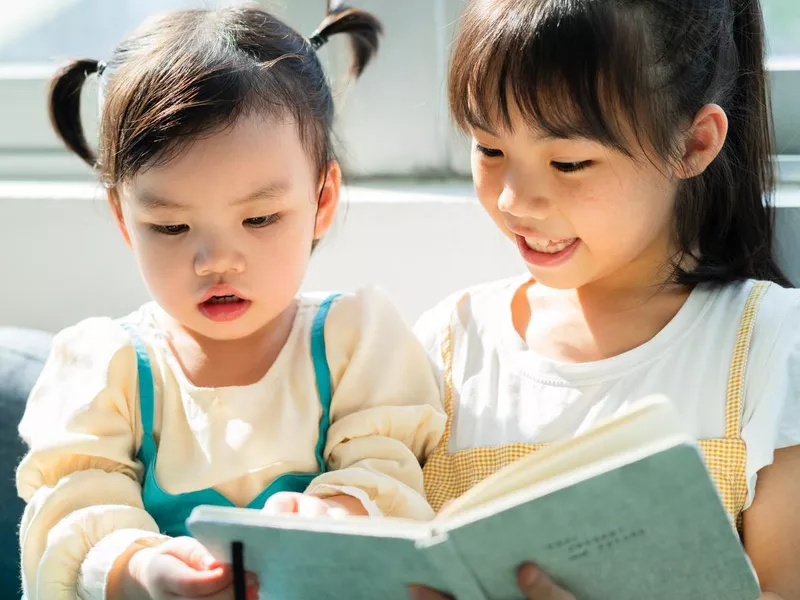 two sisters reading