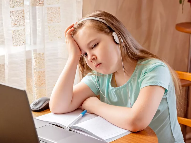 Young student bored and tired browsing laptop