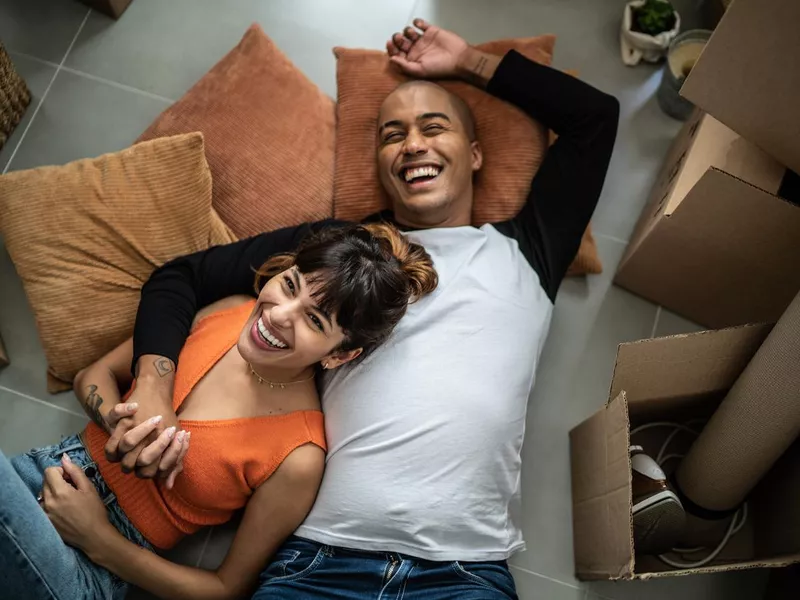 Happy young couple lying on the floor at new home