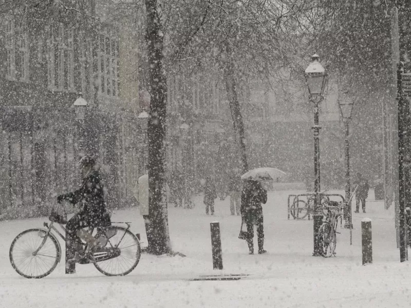 Heavy Snow Falling in Town Square with People Walking