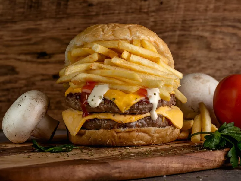 Grilled beef burger with fries on top