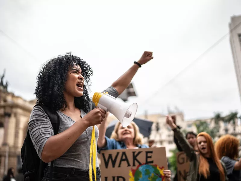 Young woman leading a demonstration using a megaphone