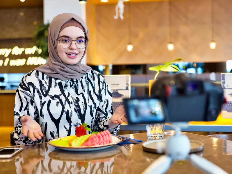 Social media influencer recording her vlog at a restaurant