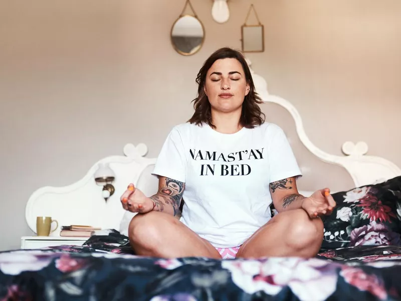 Woman meditating in bed