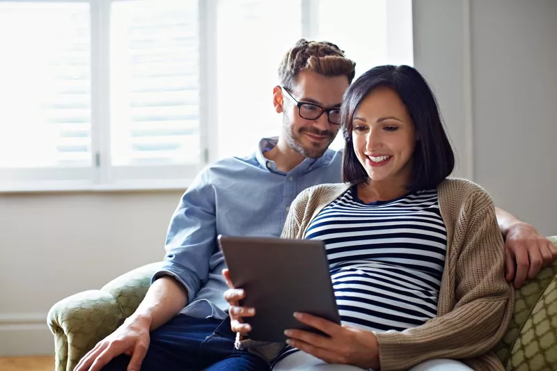 Expectant parents reading up on parenting tips